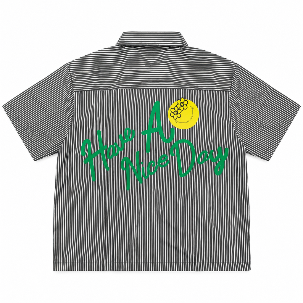 A short-sleeve button-up shirt with thin black and white vertical stripes, featuring a green 'Have A Nice Day' text graphic and a yellow smiley face with a beehive on the back.