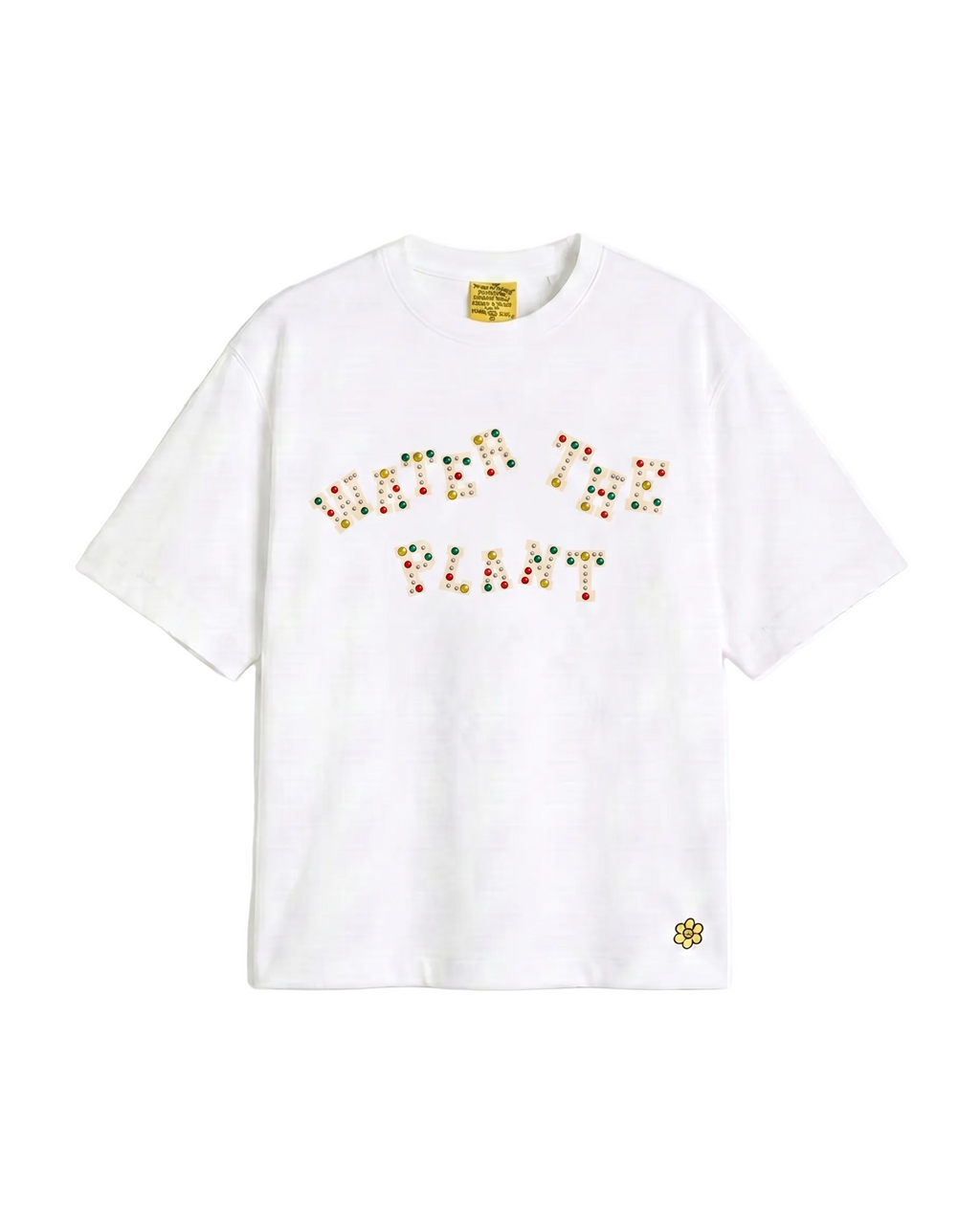 A white short-sleeve crewneck t-shirt featuring the phrase 'WATER THE PLANT' spelled out in colorful charms across the chest, with a Water The Plant flower logo on the lower left hem.