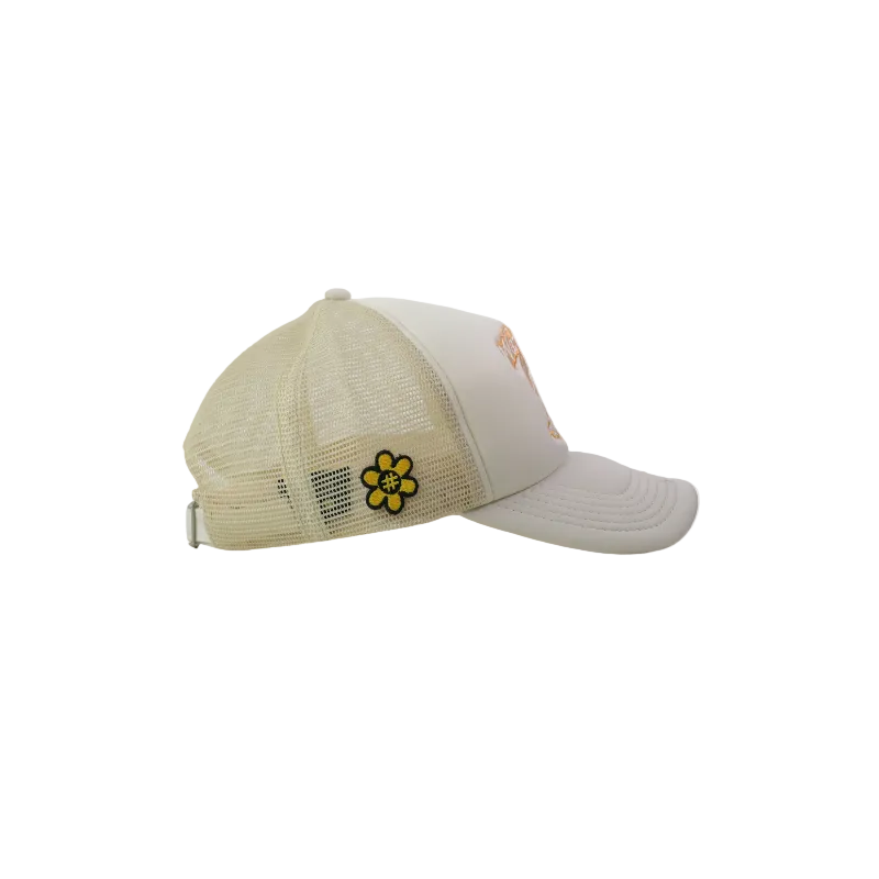 A white and beige mesh trucker hat with a small yellow embroidered flower patch on the side.