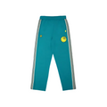 A pair of teal track pants with white and black side stripes, featuring a yellow smiley® face patch on the left thigh and a small yellow water the plant flower patch on the right thigh, shown against a plain white background.