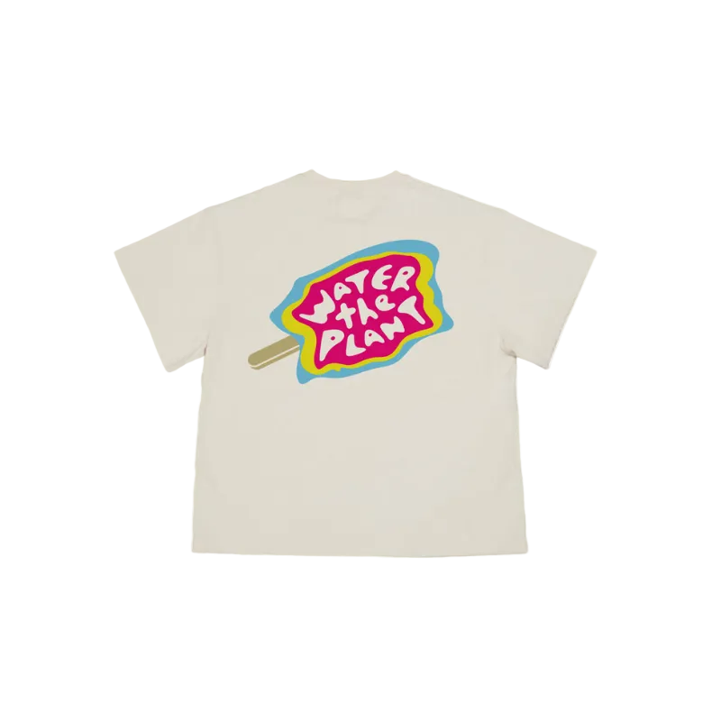 An off-white short-sleeve t-shirt with a colorful graphic on the front depicting a popsicle stick with the text 'WATER THE PLANT' in white lettering.