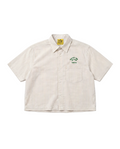 A short-sleeve button-up shirt with thin vertical beige and brown stripes, featuring a green embroidered chest logo that reads 'WATER THE PLANT TOKYO' with a tree graphic. The shirt is laid flat against a clean white background.