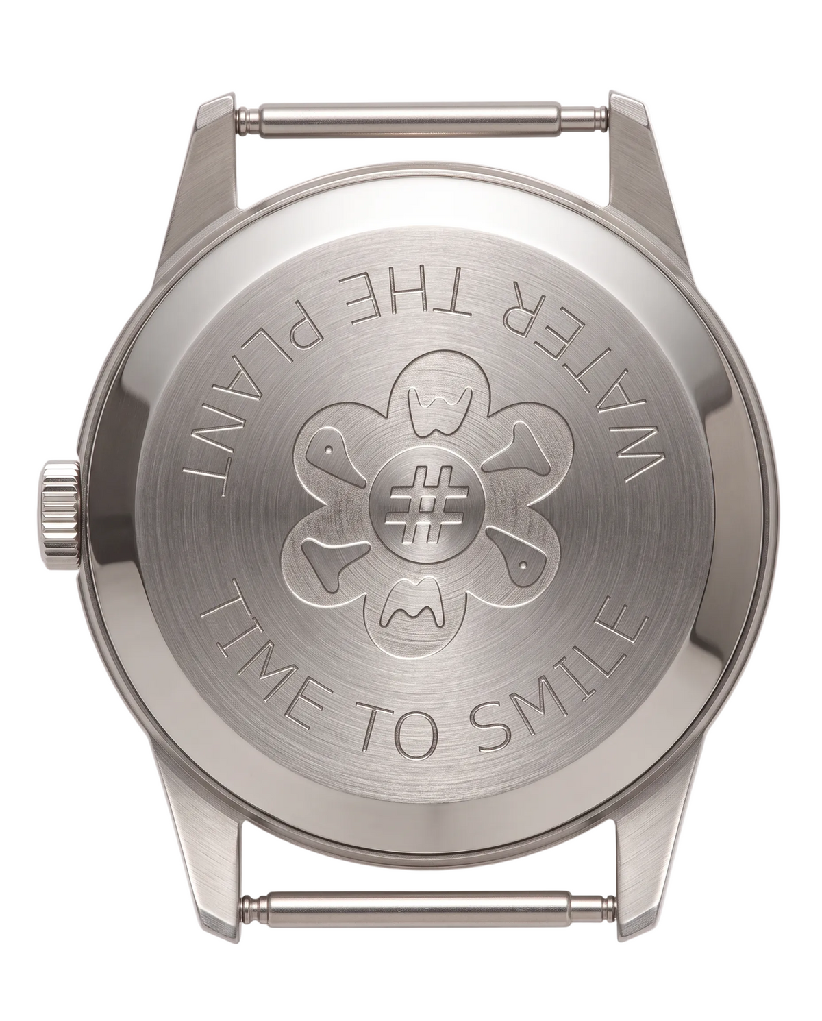 The back of a stainless steel watch case with a brushed finish, featuring an engraved flower design with a hashtag in the center and the words 'WATER THE PLANT' and 'TIME TO SMILE' around the border.