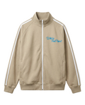 A beige zip-up track jacket featuring white stripes down the sleeves and a blue 'WATER THE PLANT' graphic on the left chest, displayed on a clean white background.