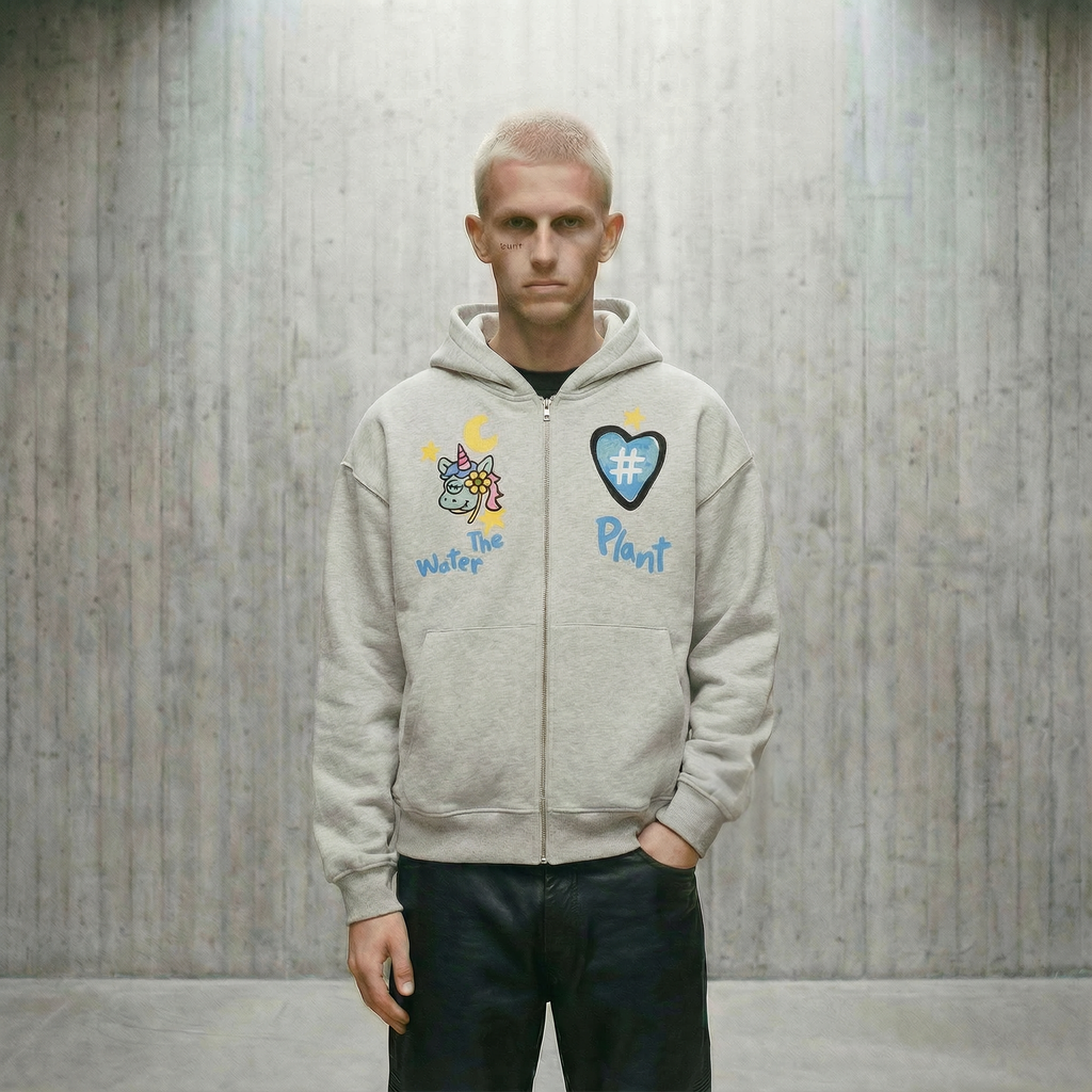 Person wearing a light gray hoodie with colorful graphics and text against a wooden paneled wall.