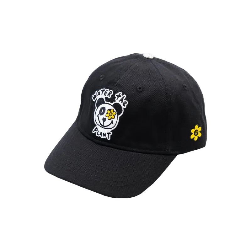 A black baseball cap featuring a white embroidered panda face with a yellow flower in its eye, accompanied by the text 'Water The Plant' on the front, and a small yellow flower on the side.