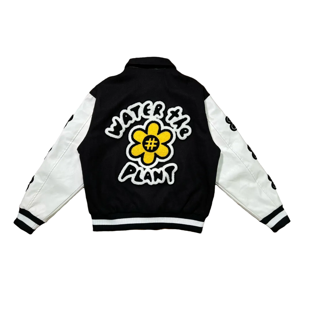 Black and white jacket with a yellow flower design and text on the back against a white background