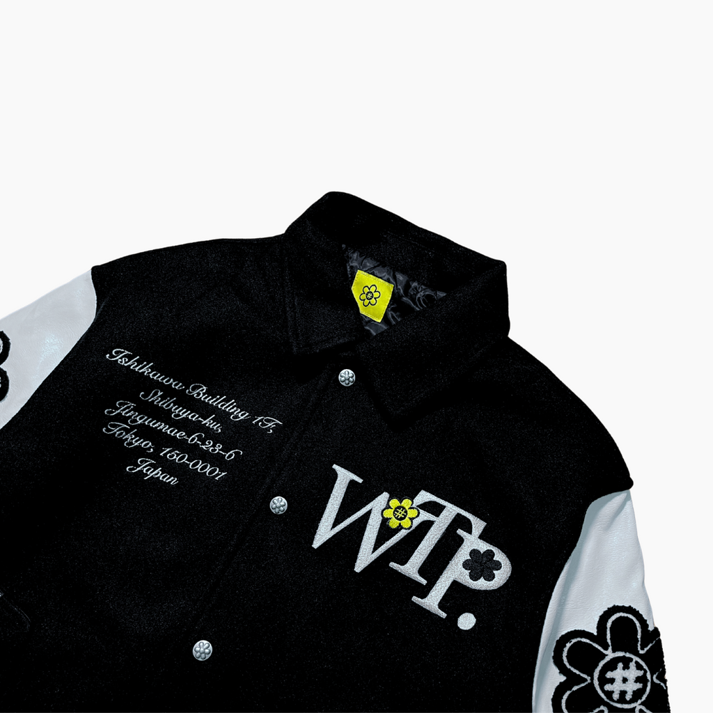 Black and white jacket with 'WTP' logo on a light gray background